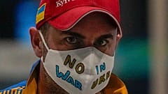 A Ukrainian journalist wearing a face mask bearing the words "No War in Ukraine" walks through the Main Media Center ahead of the 2022 Winter Paralympics in Beijing, China