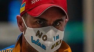 A Ukrainian journalist wearing a face mask bearing the words "No War in Ukraine" walks through the Main Media Center ahead of the 2022 Winter Paralympics in Beijing, China