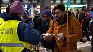 Refugees who have arrived from Ukraine are given warm drinks and something to eat at a counter after their arrival at Berlin's main train station, Germany, Thursday, March 3,