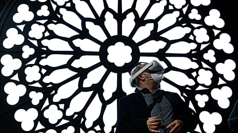 A man uses a virtual reality glasses at the stand of Orange to visit Notre Dame Cathedral at the MWC (Mobile World Congress) in Barcelona on March 2, 2022. 