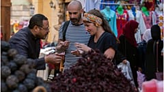 سائحان فرنسيان ليتيسيا وكريستوف يشترون التوابل من السوق التقليدي في أسوان بمصر