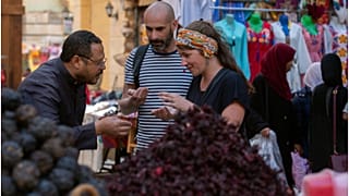 سائحان فرنسيان ليتيسيا وكريستوف يشترون التوابل من السوق التقليدي في أسوان بمصر