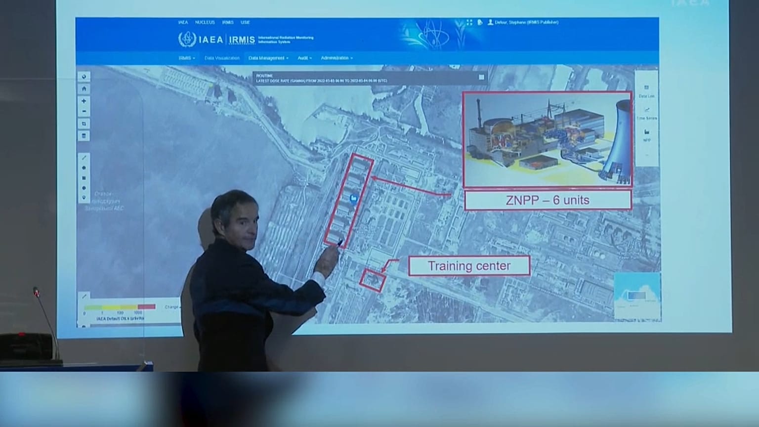 Le chef de l'aiea montrant les six réacteurs et (en bas) le centre d'entraînement touché