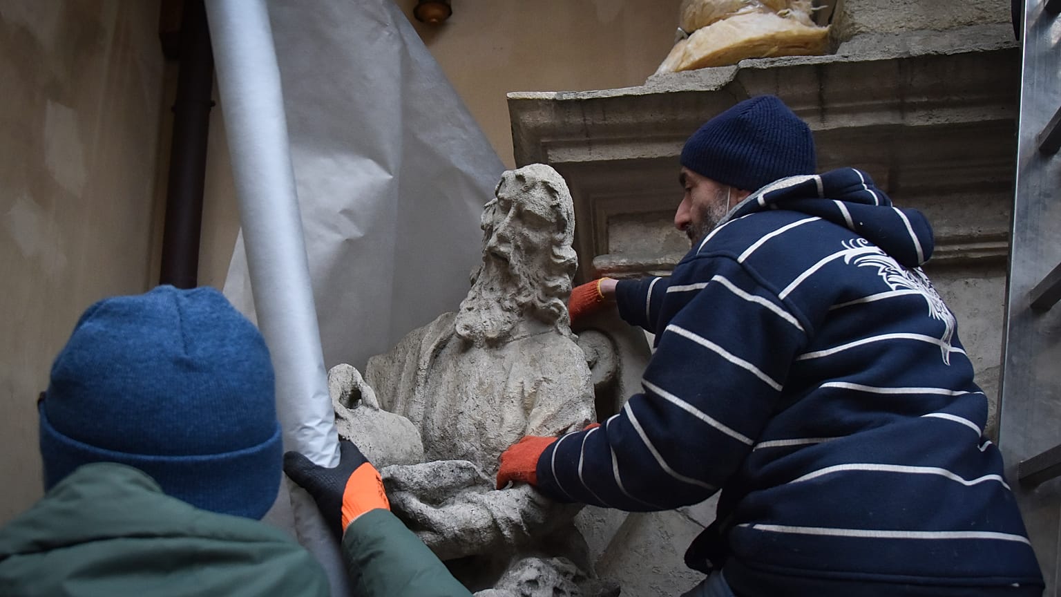 Ucranianos envuelven con materiales protectores una estatua en Lviv para preservarlas ante los bombardeos rusos, Ucrania, el 4 de marzo de 2022.
