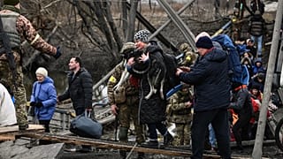 Residenti fra le macerie di Irpin, alle porte di Kyiv. Qui un'intera famiglia ha perso la vita mentre tentava la fuga