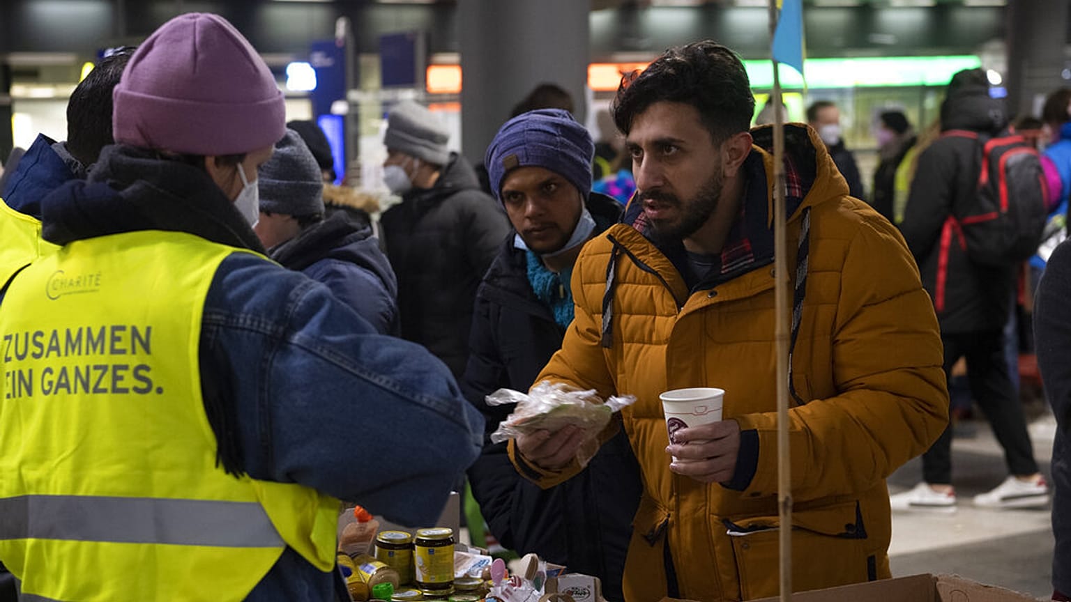 Varios refugiados reciben bebidas y alimentos calientes en la principal estación de tren de Berlín. 3 de marzo de 2022