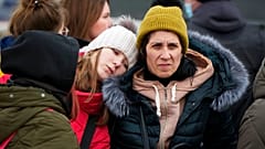 Refugees comfort each other after fleeing the war from neighbouring Ukraine, at the border crossing in Palanca, Moldova, Monday, March 7, 2022