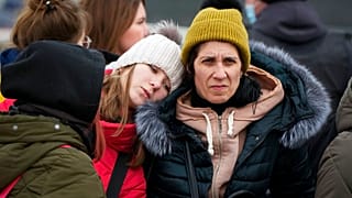 Refugees comfort each other after fleeing the war from neighbouring Ukraine, at the border crossing in Palanca, Moldova, Monday, March 7, 2022