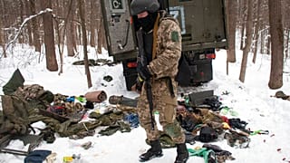 Un voluntario de las Fuerzas de Defensa Territorial de Ucrania inspecciona un vehículo militar dañado en las afueras de Kharkiv, el lunes 7 de marzo de 2022