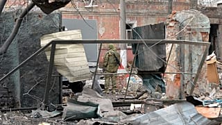 Украинский военнослужащий смотрит на разрушения после обстрела Харькова 7 марта 2022 года.