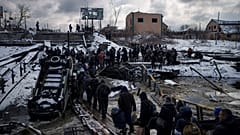 Ukrainians cross an improvised path under a destroyed bridge while fleeing Irpin, in the outskirts of Kyiv, Ukraine