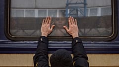 Aleksander (41) presst seine Handflächen gegen das Fenster, während er sich von seiner Tochter Anna (5) in einem Zug nach Lviv am Bahnhof von Kiew verabschiedet. 4. März 2022.
