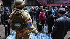 Militares ucranianos distribuem água às pessoas em Mariupol