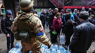 Militares ucranianos distribuem água às pessoas em Mariupol