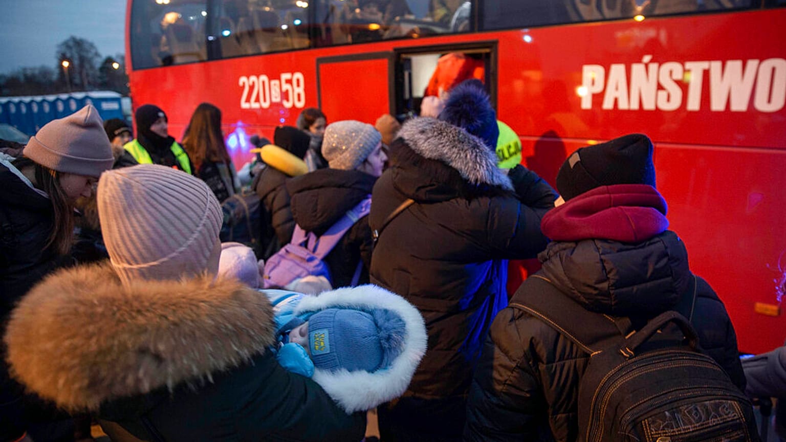 Flüchtlinge, meist Frauen mit Kindern, warten nach ihrer Ankunft am Grenzübergang in Medyka, Polen, auf den Einstieg in einen Bus, 08.03.2022