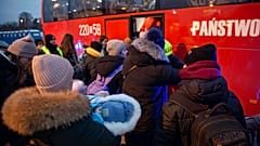 Flüchtlinge, meist Frauen mit Kindern, warten nach ihrer Ankunft am Grenzübergang in Medyka, Polen, auf den Einstieg in einen Bus, 08.03.2022