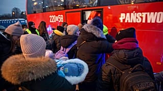 Flüchtlinge, meist Frauen mit Kindern, warten nach ihrer Ankunft am Grenzübergang in Medyka, Polen, auf den Einstieg in einen Bus, 08.03.2022