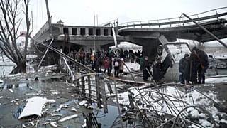 People fleeing the fighting crossing the river under a destroyed bridge to reach Kyiv.