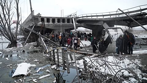  People fleeing the fighting crossing the river under a destroyed bridge to reach Kyiv.