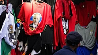 Un homme regarde un T-shirt avec une photo du président russe Vladimir Poutine dans la principale rue piétonne de Belgrade, en Serbie, samedi 26 février 2022.