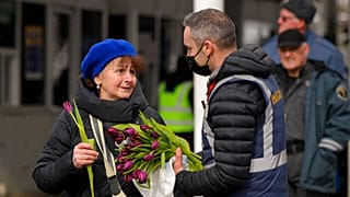 Un garde-frontière roumain offre une fleur à une réfugiée arrivant d'Ukraine - Siret (Roumanie), le 08/03/2022