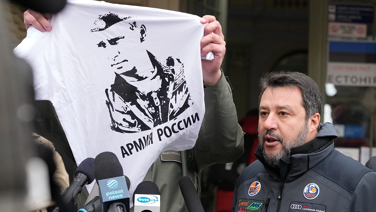 Przemysl's mayor Wojciech Bakun holds up a t-shirt with the likeness of Russian President Vladimir Putin and the words "The Russian Army" as he stands alongside Matteo Salvini