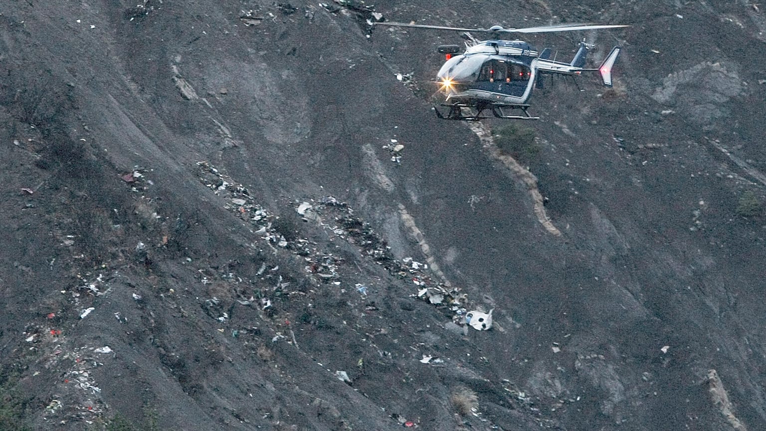 A rescue helicopter flies over debris of the Germanwings Airbus A320-211 near Seyne-les-Alpes.