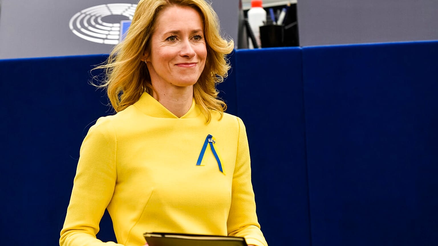 Estonian Prime Minister Kaja Kallas, wearing a dress and a ribbon under the colors of Ukraine, arrives to deliver a speech during a debate on EU's role.