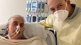 David Bennett Jr, right, stands next to his father's hospital bed in Baltimore, US, on January 12, 2022, five days after doctors transplanted a pig heart into Bennett Sr.
