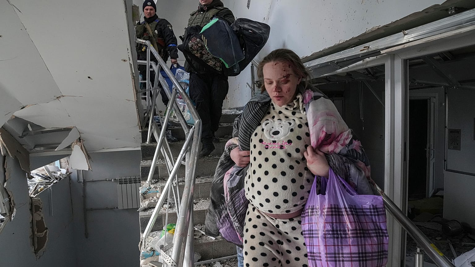Una mujer embarazada herida baja las escaleras del hospital de maternidad dañado por los bombardeos en Mariupol, Ucrania, el miércoles 9 de marzo de 2022