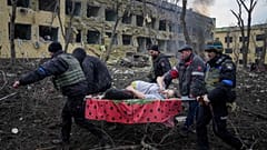 Ukrainian emergency employees and volunteers carry an injured pregnant woman from the damaged by shelling maternity hospital in Mariupol, Ukraine, March 9, 2022.