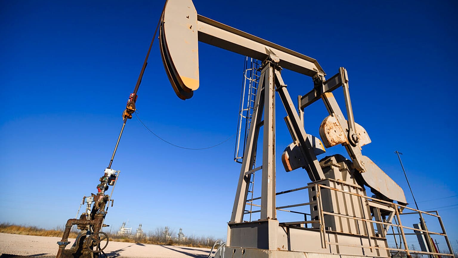 A pumpjack operates just outside of the Odessa Ector Power Partners natural gas power plant 