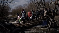 Ukrainians cross an improvised path under a destroyed bridge while fleeing Irpin, on the outskirts of Kyiv, Ukraine, Wednesday, March 9, 2022. 