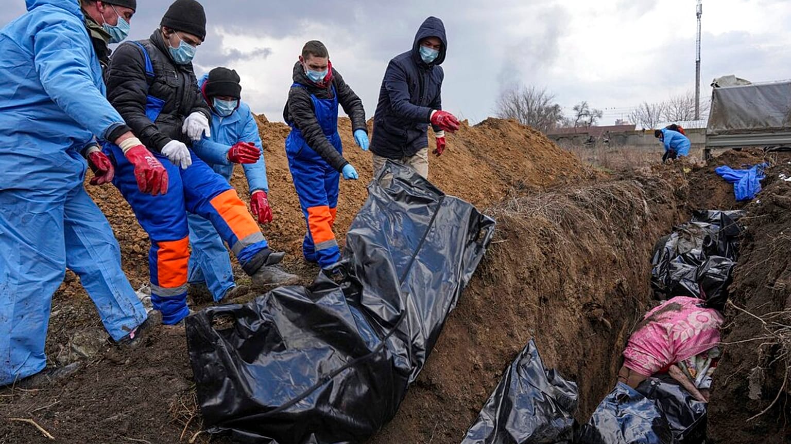 Dead bodies are placed into a mass grave on the outskirts of Mariupol