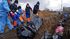 Dead bodies are placed into a mass grave on the outskirts of Mariupol