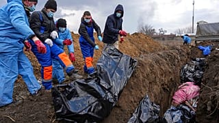 Dead bodies are placed into a mass grave on the outskirts of Mariupol