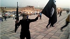مقاتل لتنظيم داعش يحمل عمل التنظيم 