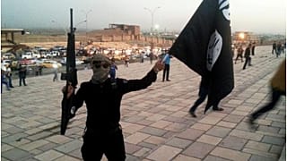 مقاتل لتنظيم داعش يحمل عمل التنظيم 