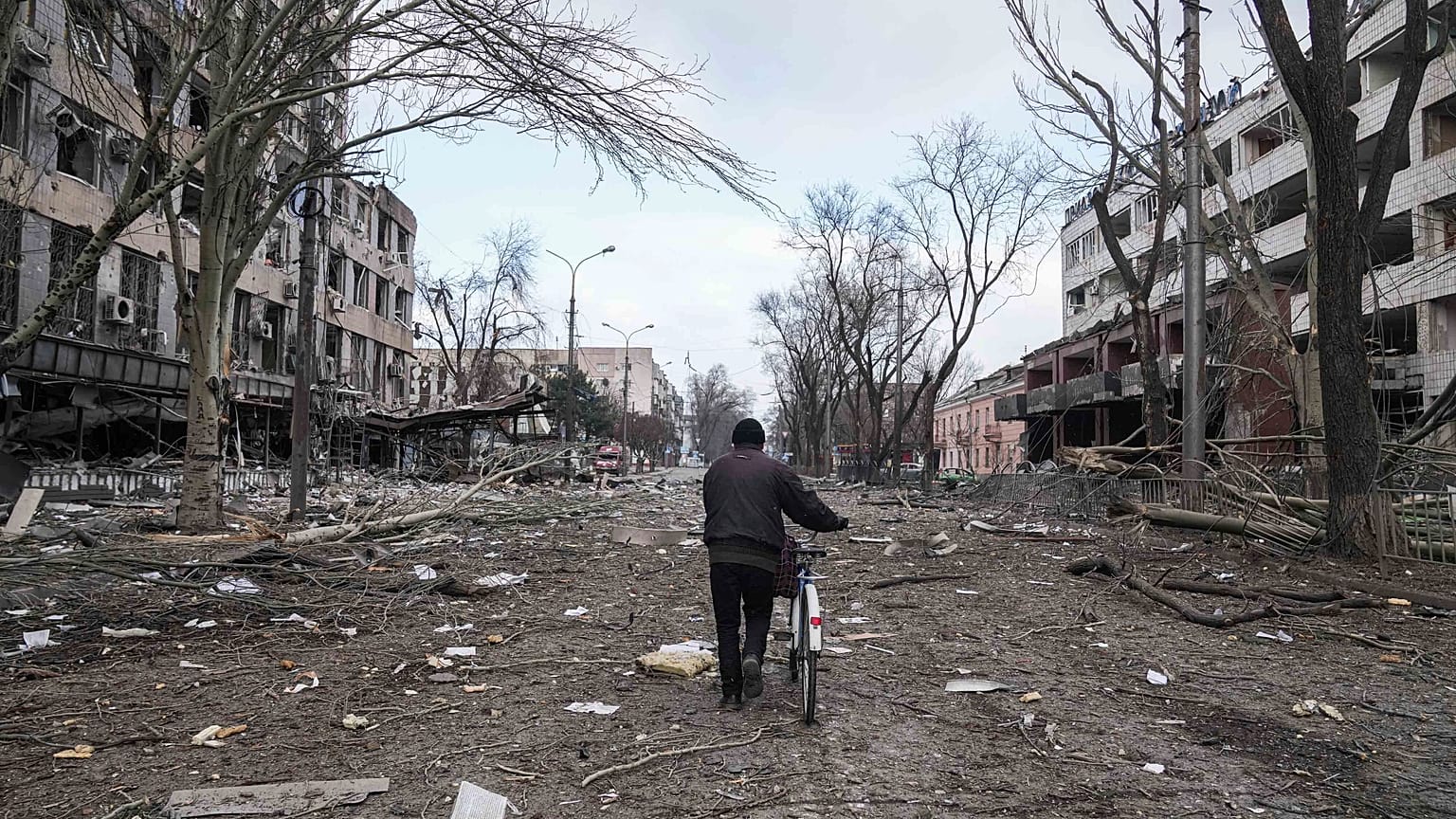 A man walks with a bicycle in a street damaged by shelling in Mariupol, Ukraine, Thursday, 10 March , 2022. 