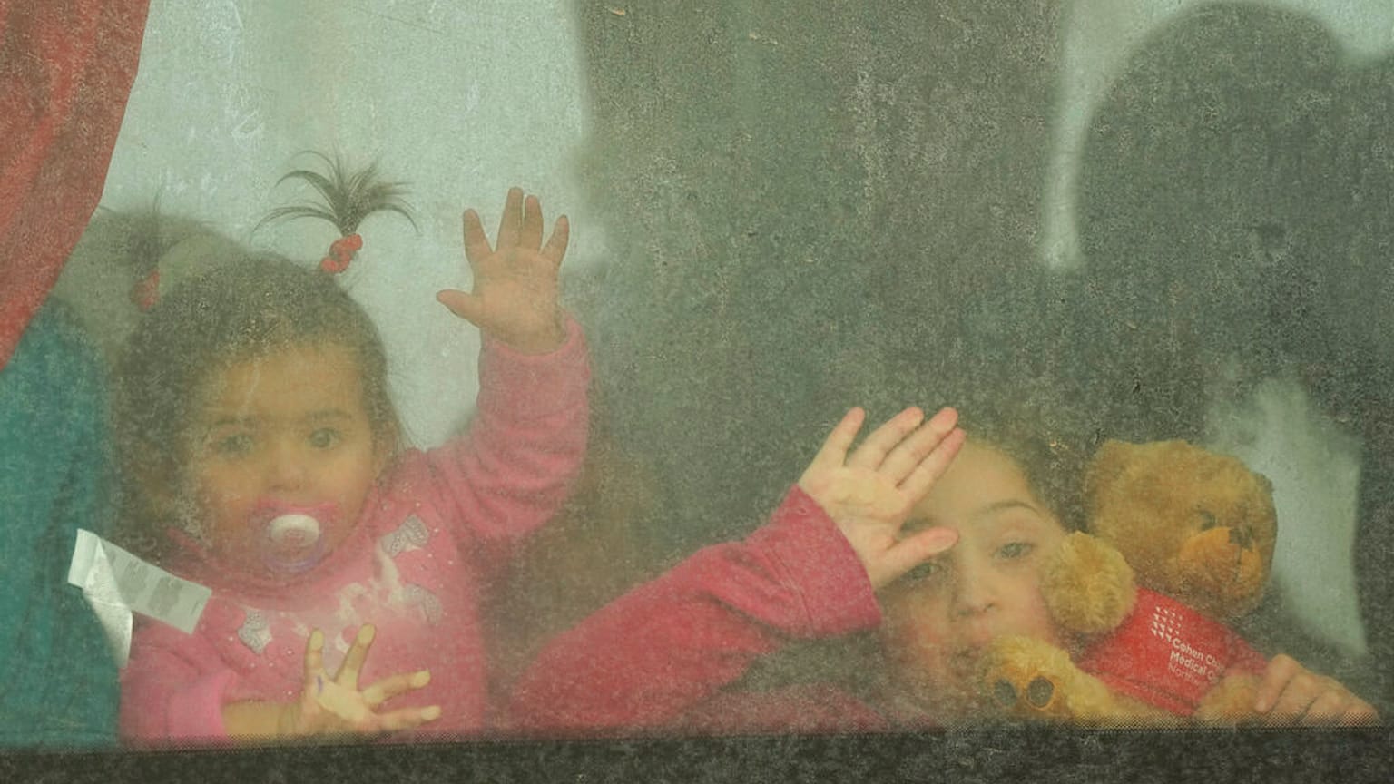 Niños refugiados miran desde un autobús que parte hacia Rumanía tras huir de la guerra de la vecina Ucrania