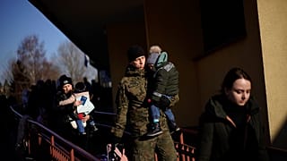 Un soldado polaco sostiene a un niño mientras los refugiados ucranianos llegan de Lviv a la estación de tren de Przemysl, en el sureste de Polonia, el 11 de marzo de 2022.