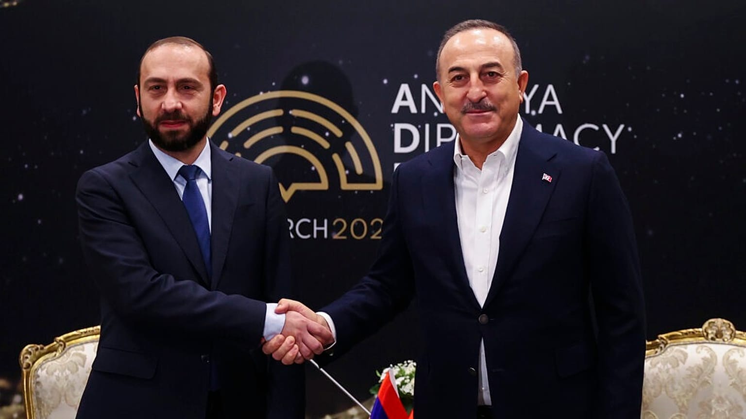 Ararat Mirzoyan (à esquerda) aperta a mão a Mevlut Cavusoglu, em Antalia, no sul da Turquia