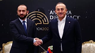 Ararat Mirzoyan (à esquerda) aperta a mão a Mevlut Cavusoglu, em Antalia, no sul da Turquia