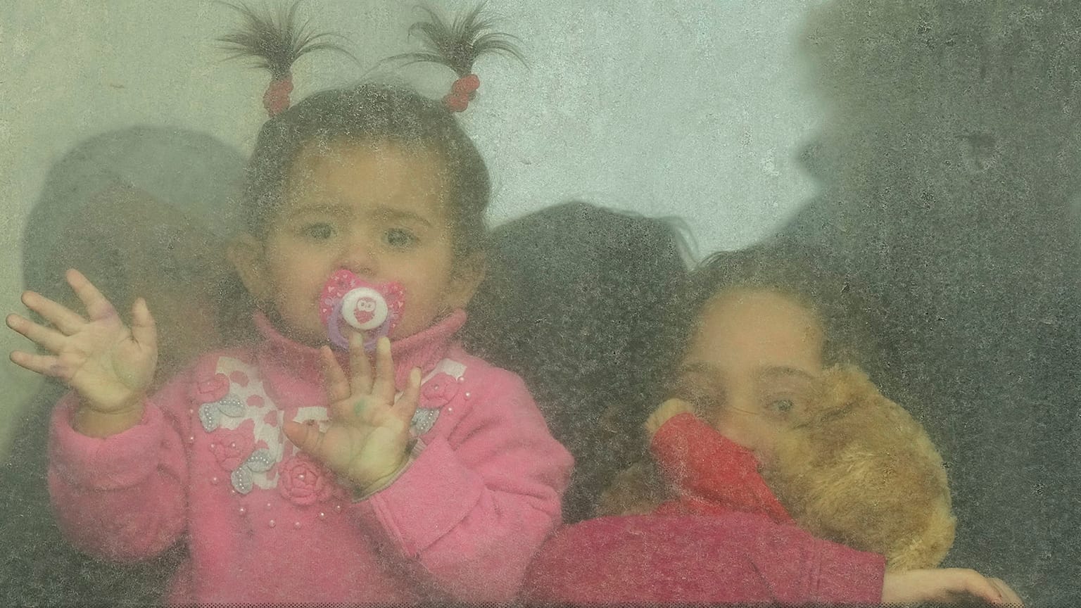 Refugee children look out from a bus leaving to Romania after fleeing the war from neighbouring Ukraine in Palanca, Moldova