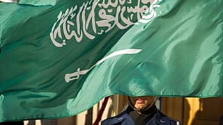 A US Honor Guard member is covered by the flag of Saudi Arabia as Defence Secretary Jim Mattis welcomes Saudi Crown Prince Mohammed bin Salman to the Pentagon in 2019.