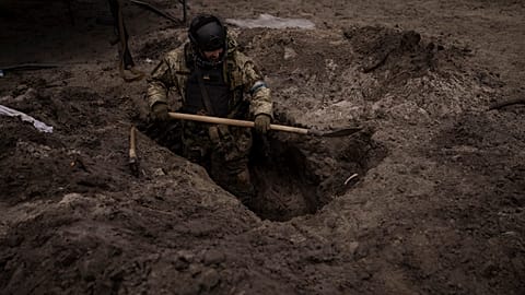 A Ukrainian soldier digs a foxhole in Irpin, outskirts of Kyiv, Ukraine, Sunday, 13 March 2022