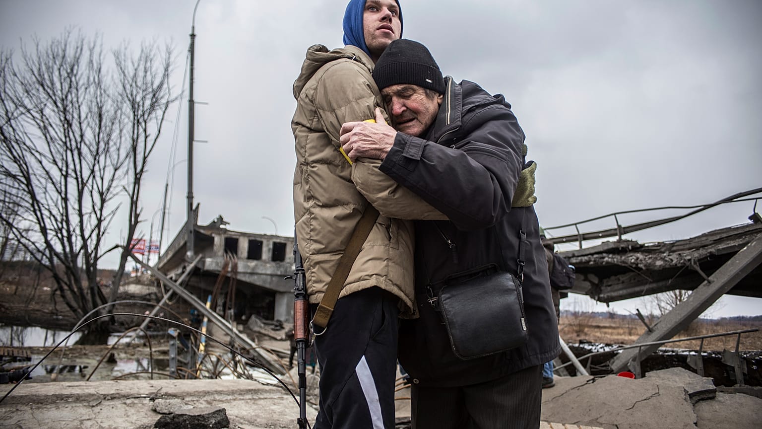 Un membre des forces ukrainiennes soutient un habitant d'Irpin, qui s'apprête à quitter sa ville, Ukraine, le 9 mars 2022