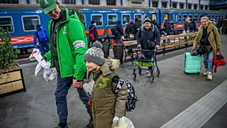Önkéntes segít a háború miatt Ukrajnából menekülő embereknek Budapesten, a Nyugati pályaudvaron 2022. március 1-jére virradóan