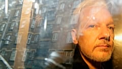 FILE - In this Wednesday May 1, 2019 file photo buildings are reflected in the window as WikiLeaks founder Julian Assange is taken from court in London.