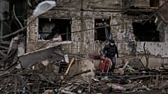 People retrieve belongings from an apartment in a block which was destroyed by an artillery strike in Kyiv, Ukraine, Monday, March 14, 2022. 